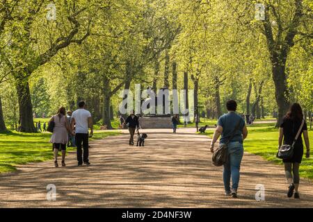 Bellissimo parco con alberi che costeggiano un sentiero e una statua di un uomo e un cavallo in lontananza. Hyde Park Londra Foto Stock