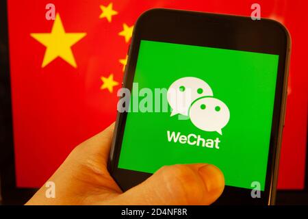 Cellulare con icone WeChat e TikTok di fronte alla bandiera della Cina. il presidente degli Stati Uniti Donald Trump vieta le applicazioni della Cina a causa della sicurezza nazionale. Foto Stock