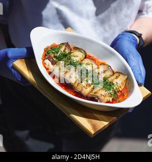 Melanzane farcite con ricotta in salsa di pomodoro e servite con parmigiano in primo piano in un piatto Foto Stock