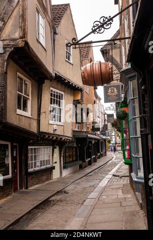 Regno Unito, Inghilterra, Yorkshire, York, Shambles, gli edifici a graticcio sospesi in legno d'acqua incorniciati in una stretta corsia acciottolata Foto Stock