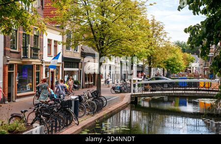 Vista sul centro storico di Gouda. Zeugstraat con canale, ponti e negozi in un pomeriggio di sole. Olanda meridionale, Paesi Bassi. Foto Stock
