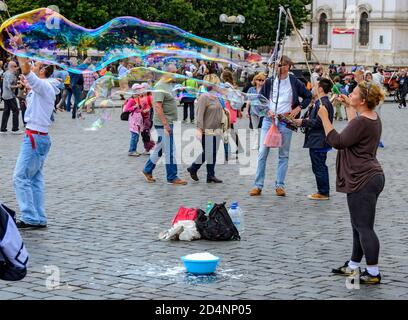 Artista di strada femminile con gigantesche bolle di sapone sulla Piazza della Città Vecchia di Praga, Repubblica Ceca Foto Stock