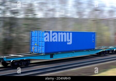 Freight train with cargo containers on railway with motion blur effect Foto Stock