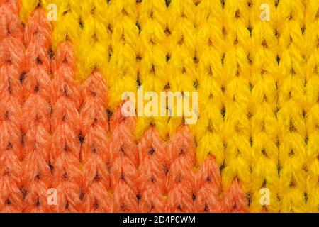 Primo piano in tessuto sintetico giallo e rosso. Tessuto lavorato a maglia. Tessuto lavorato a maglia multicolore. Sfondo Foto Stock