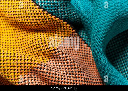 Una pila di tessuti sintetici multicolore a maglia di strutture e trame diverse. Una pila di tessuti colorati forme lisce sfondo. Multicolo Foto Stock