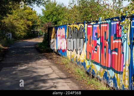 Sito di Cherry Orchard Lane Brickworks, Rochford, Southend, Essex, UK. Graffiti coperta con vecchi binari stretti lungo il ponte, percorso Foto Stock