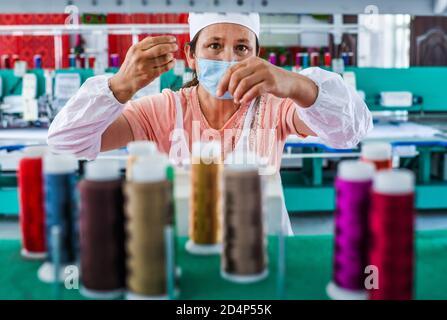 (201010) -- URUMQI, 10 ottobre 2020 (Xinhua) -- UN abitante del villaggio fa il tessuto ad una cooperativa di ricami nella contea di Tekes, nella regione autonoma di Xinjiang Uygur della Cina nord-occidentale, 3 luglio 2020. Grazie agli sforzi intensamente compiuti da tutte le parti, sono stati compiuti grandi progressi in Xinjiang. Dal 2014 al 2019, è stato sostenuto un forte slancio economico con un tasso medio annuo di crescita del PIL del 7.2 per cento. Gli standard di vita della popolazione locale sono significativamente migliorati con una crescita media annua del 9.1% del reddito disponibile residenziale pro capite, e più di 2.92 milioni di persone su 3.09 milioni di registi Foto Stock