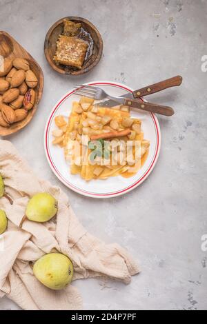 Frittelle di sottile (crepes) con ripieno di mele, rotoli farciti, Russo del cibo tradizionale per maslenitsa, francese dessert, prima colazione con i tulipani sulla madre d Foto Stock