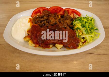 Iskender kebap o Iskender döner è uno dei famosi piatti kebab della regione 'Bursa/ Turchia'. Kebab di salsiccia (sucuk turco). Foto Stock