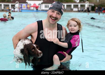 Cheltenham, Regno Unito. 10 ottobre 2020. Christopher Bermingham con sua figlia Ciara, 2 anni, e il loro animale domestico spaniel, Tattinger, 5. I cani e i loro proprietari hanno la possibilità di nuotare insieme al Sandford Park Lido, una piscina all'aperto a Cheltenham, Gloucestershire, Regno Unito, l'ultimo giorno della stagione estiva, prima che la piscina chiuda per l'anno. Credit: Thousand Word Media Ltd/Alamy Live News Foto Stock