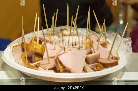 Carne tagliata a fette per la degustazione su un piatto con spiedini Foto Stock