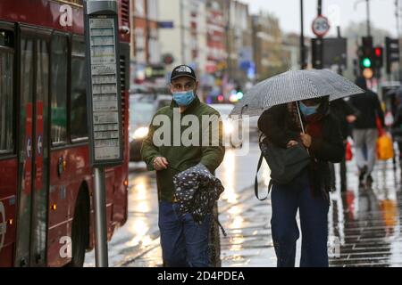Londra, Regno Unito. 09 ottobre 2020. Un uomo visto indossare un facemask aspetta a una fermata di autobus a Londra. I passeggeri che viaggiano con i mezzi pubblici devono indossare maschere per il viso come precauzione contro la diffusione del Covid-19. Credit: SOPA Images Limited/Alamy Live News Foto Stock