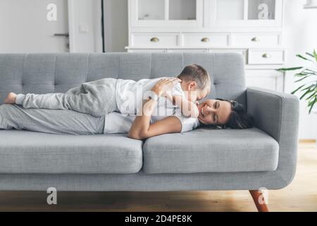Madre con suo figlio su un divano nel loro vivere camera Foto Stock
