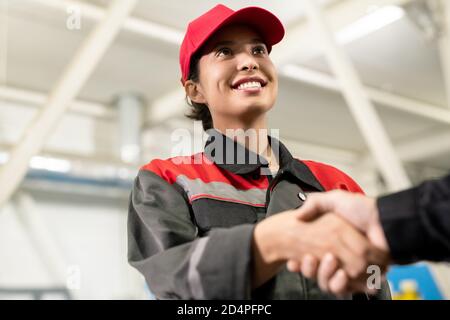 Giovane allegra ingegnere femminile in abbigliamento da lavoro guardando la collega o. caposquadra Foto Stock