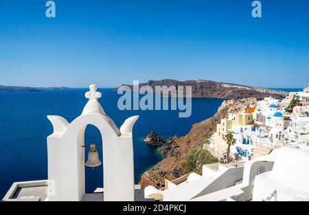 Vista panoramica della caldera di Santorini con la città di Oia e famoso vecchie campane bianche e cupole blu di chiese ortodosse Foto Stock