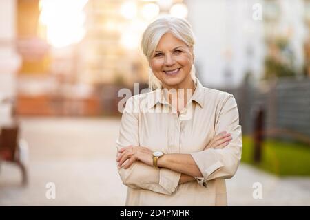 Ritratto di una donna anziana fiduciosa in città Foto Stock