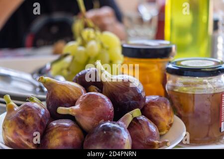 Fichi interi purpuri freschi, ficus carica e conservi di questi frutti dolci con vitamine e calorie. Cibo di nutrizione adeguato per vegan, vegetariano, Foto Stock