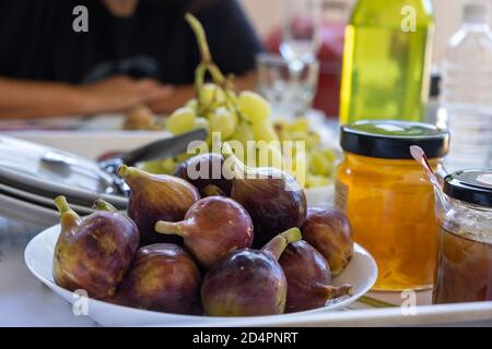 Fichi interi purpuri freschi, ficus carica e uva con vitamine e calorie. Alimentazione adeguata per vegan, vegetariano, dieta. Stile di vita sano Foto Stock