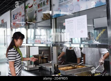 (201010) -- SHENZHEN, 10 ottobre 2020 (Xinhua) -- Xiong Yonglan ispeziona la sala da pranzo presso il palazzo giovanile del distretto di Bao'an a Shenzhen, provincia del Guangdong della Cina meridionale, 8 settembre 2020. Xiong Yonglan, che ora è un direttore presso il palazzo giovanile del distretto di Bao'an a Shenzhen, si è sforzata per una vita migliore nella città dal momento in cui è entrata nella città. Nel 1992, Xiong Yonglan, 18 anni, è venuto alla filiale di Shenzhen di Mabuchi Motor e ha lavorato alla linea di assemblaggio. Presto, con le sue eccezionali prestazioni sul lavoro, Xiong divenne un ispettore di qualità a tempo pieno. Nel suo tempo libero, sh Foto Stock