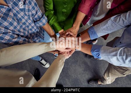 Vista dall'alto di diverse persone che fanno affari di etnia si sono urla, celebrando il successo mentre si è in piedi in ufficio. Lavoro di squadra e concetto di cooperazione Foto Stock