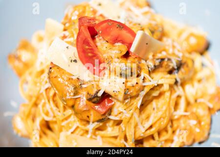 Gustosa e appetitosa pasta italiana di spaghetti con salsa, parmigiano e basilico sul piatto. Foto Stock