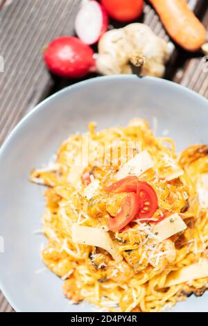 Gustosa e appetitosa pasta italiana di spaghetti con salsa, parmigiano e basilico sul piatto. Foto Stock