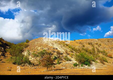 Nuvole basse sulla collina . Paesaggio roccioso Foto Stock