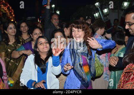 Danze della signora straniero e godendo di una processione indiana di nozze ad Agra, Uttar Pradesh, India Foto Stock