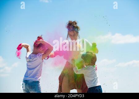 Bambini che giocano con polvere di colore. Bambini che festeggiano holi festival dei colori. Gioco di colore splash. Bambini con dipinti viso. Foto Stock