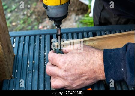 primo piano di mani falegname costruzione casa ringhiera di decking, casa migliorie Foto Stock