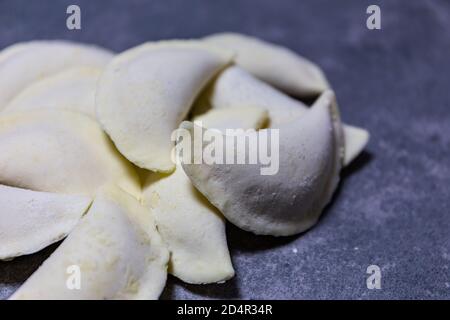 Gnocchi polacchi senza glutine (Pierogi), piatto nazionale lucidato fatto di pasta e ripieno salato o dolce. Vista ravvicinata di diversi gnocchi surgelati lisi Foto Stock