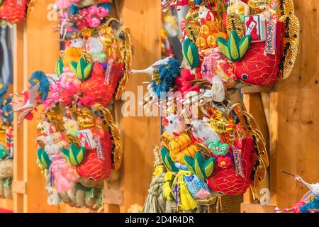 asakusa, giappone - novembre 08 2019: Primo piano su rakes auspicious o kumade kisshō in chirimen crêpe tessuto decorato con muse, orate di mare e c. Foto Stock