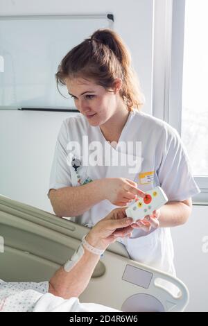 Uomo nella stanza dell'ospedale, telecomando chiamata infermiere, ospedale Bordeaux, Francia. Foto Stock