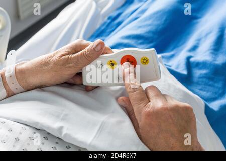 Uomo nella stanza dell'ospedale, telecomando chiamata infermiere, Francia. Foto Stock