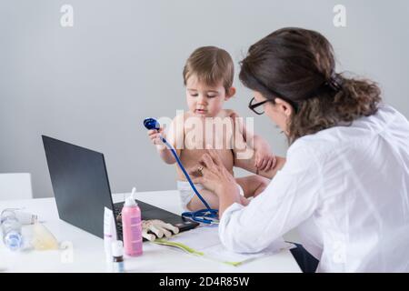 Medico e bambino di 9 mesi con un medico. Foto Stock