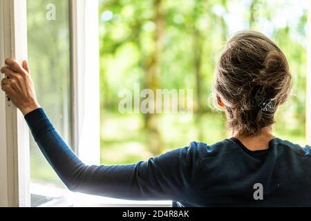 Donna finestra di apertura. Foto Stock