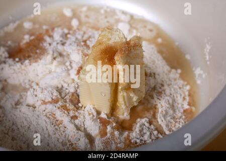 Burro, zucchero e farina in una ciotola. Impastare l'impasto. Torta di Levington, fasi di preparazione. Foto Stock