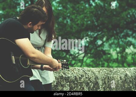 Fratello insegnava a suonare la chitarra in natura Foto Stock