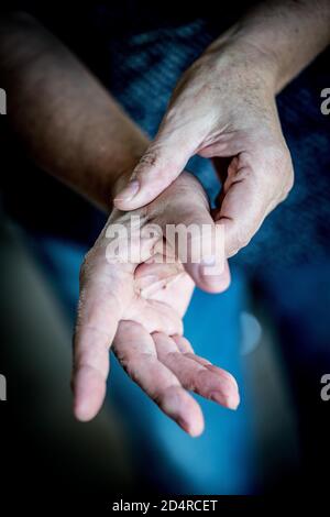 Senior donna che soffre di un dolore articolare in mano. Foto Stock