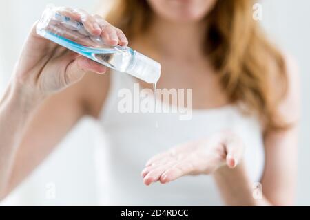 Donna lavando le mani con gel idroalcoolico. Foto Stock