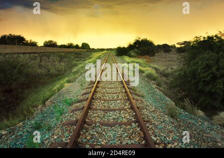 Binari ferroviari che attraversano un paesaggio arido vicino a Upington, Capo del Nord, Sud Africa Foto Stock