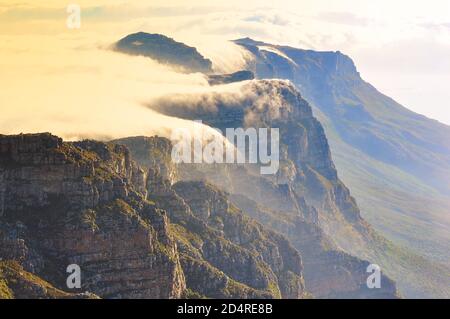 Magnifica Table Mountain coperta da una coperta nuvolosa al tramonto, Città del Capo Foto Stock