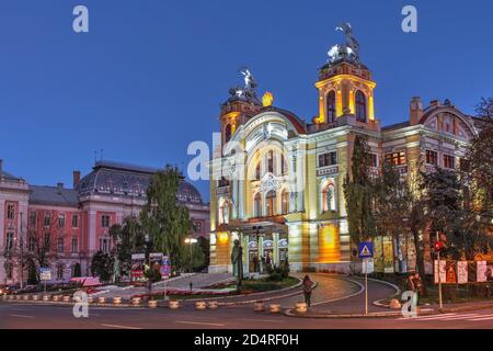 Crepuscolo a Cluj Napoca, Romania con il Teatro Nazionale Luciano Blaga e il Palazzo di Giustizia. Foto Stock