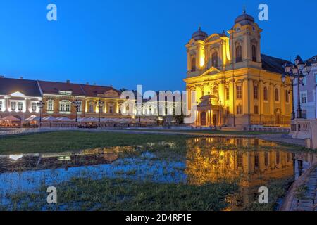 Scena notturna in Piazza Unirii (Union Square), Timisoara, Romania con la chiesa di San Giorgio (cupola), che si riflette in una piscina a seguito di una pioggia estiva. Foto Stock