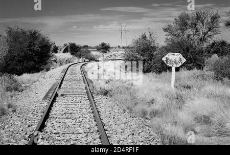 Binari ferroviari che attraversano un paesaggio arido vicino a Upington, Capo del Nord, Sud Africa Foto Stock