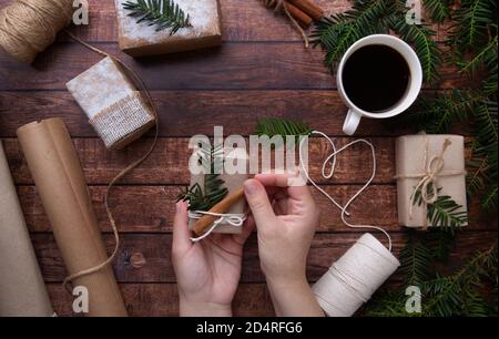 Le mani fanno il regalo di Natale sul tavolo di legno Foto Stock