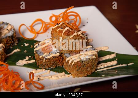 Primo piano di un piatto di tempura Maki con formaggio, cipolle e salmone Foto Stock