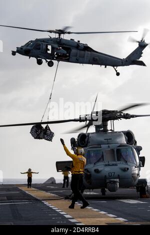 201006-N-NJ919-1124 MARE DELLE FILIPPINE (OTT 6, 2020) i marinai assegnati alla nave d'assalto anfibia USS America (LHA 6), schierata in avanti, effettuano operazioni di volo durante un rifornimento in mare. America, ammiraglia dell'America Expeditionary Strike Group, assegnato allo Squadrone anfibio 11, insieme alla 31esima unità di spedizione marina, Opera nell'area di responsabilità della settima flotta statunitense per migliorare l'interoperabilità con alleati e partner e fungere da forza di risposta pronta a difendere la pace e la stabilità nella regione dell'Indo-Pacifico. (STATI UNITI Navy Photo by Mass Communication Specialist 3a Classe Foto Stock