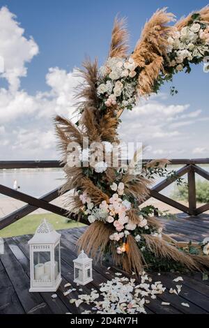 matrimonio arco rotondo in legno con fiori sul molo Foto stock - Alamy