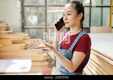 Falegname femminile che parla al telefono Foto Stock